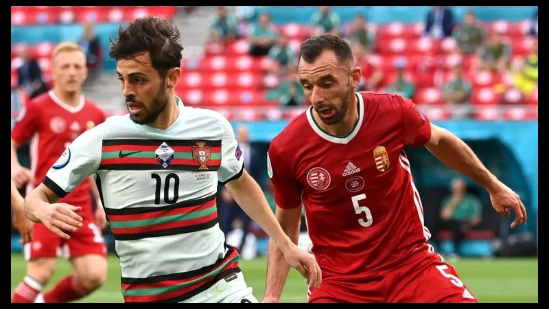 Cầu thủ Bồ Đào Nha với bóng trước sự truy đuổi từ cầu thủ Hungary trong trận đấu Cầu thủ Bồ Đào Nha với bóng trước sự truy đuổi từ cầu thủ Hungary trong trận đấu